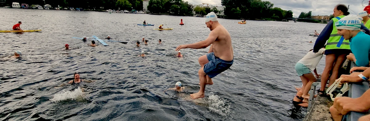 Mann springt vom Ufer in die Spree